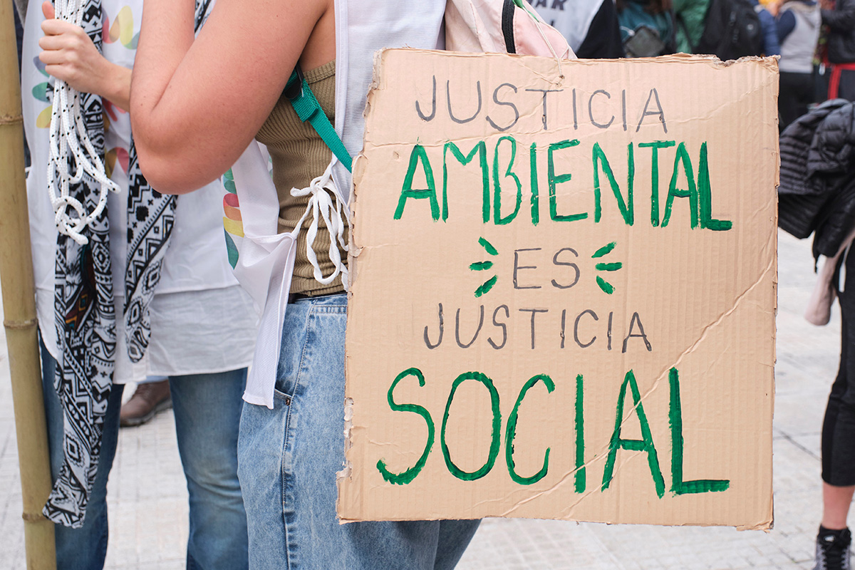 Cardboard sign that reads environmental justice is social justice in Spanish